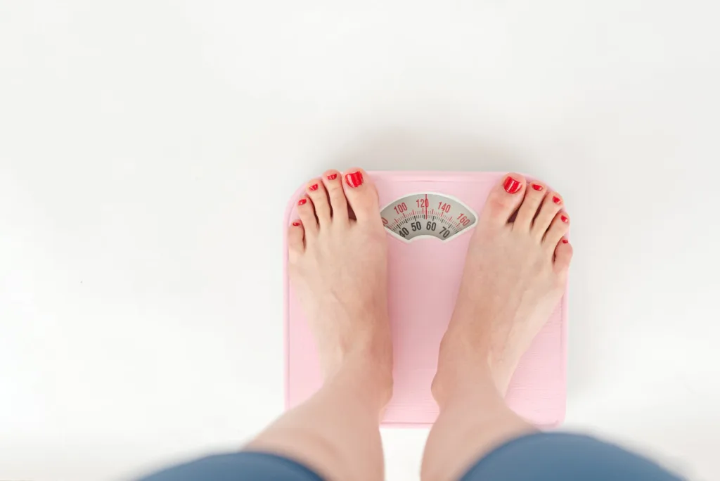 woman weighing on scales in studio weight loss